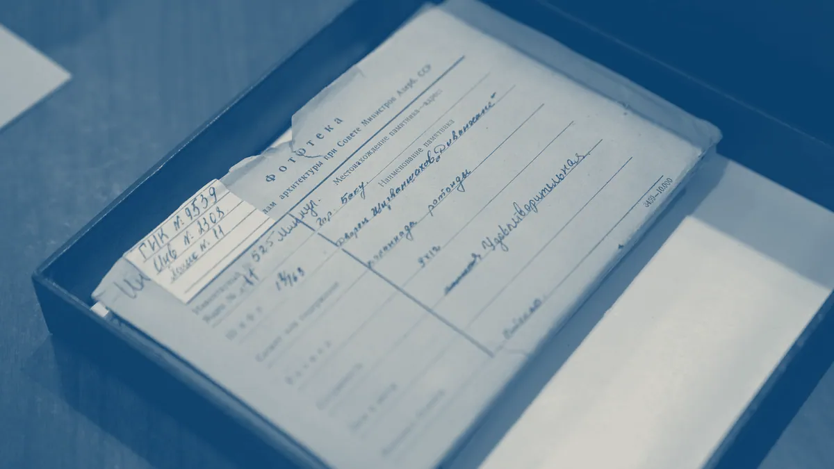Loose archive documents in a storage box.