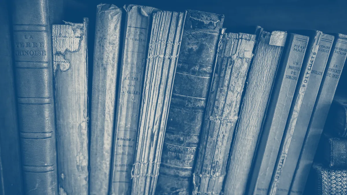 A library shelf packed with worn, bound volumes.